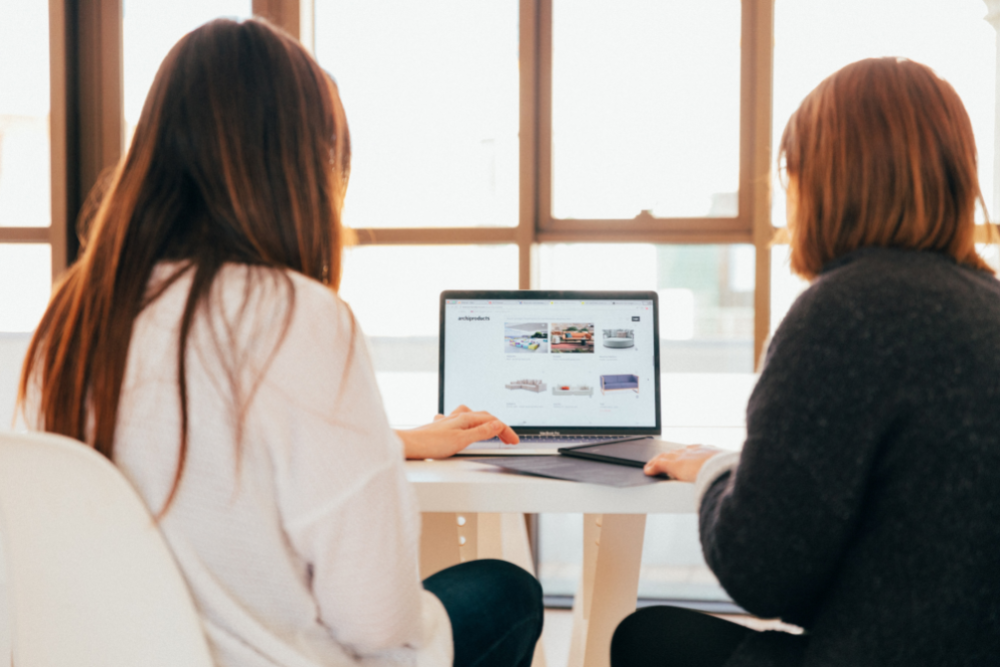 Two people looking through images on a furniture website